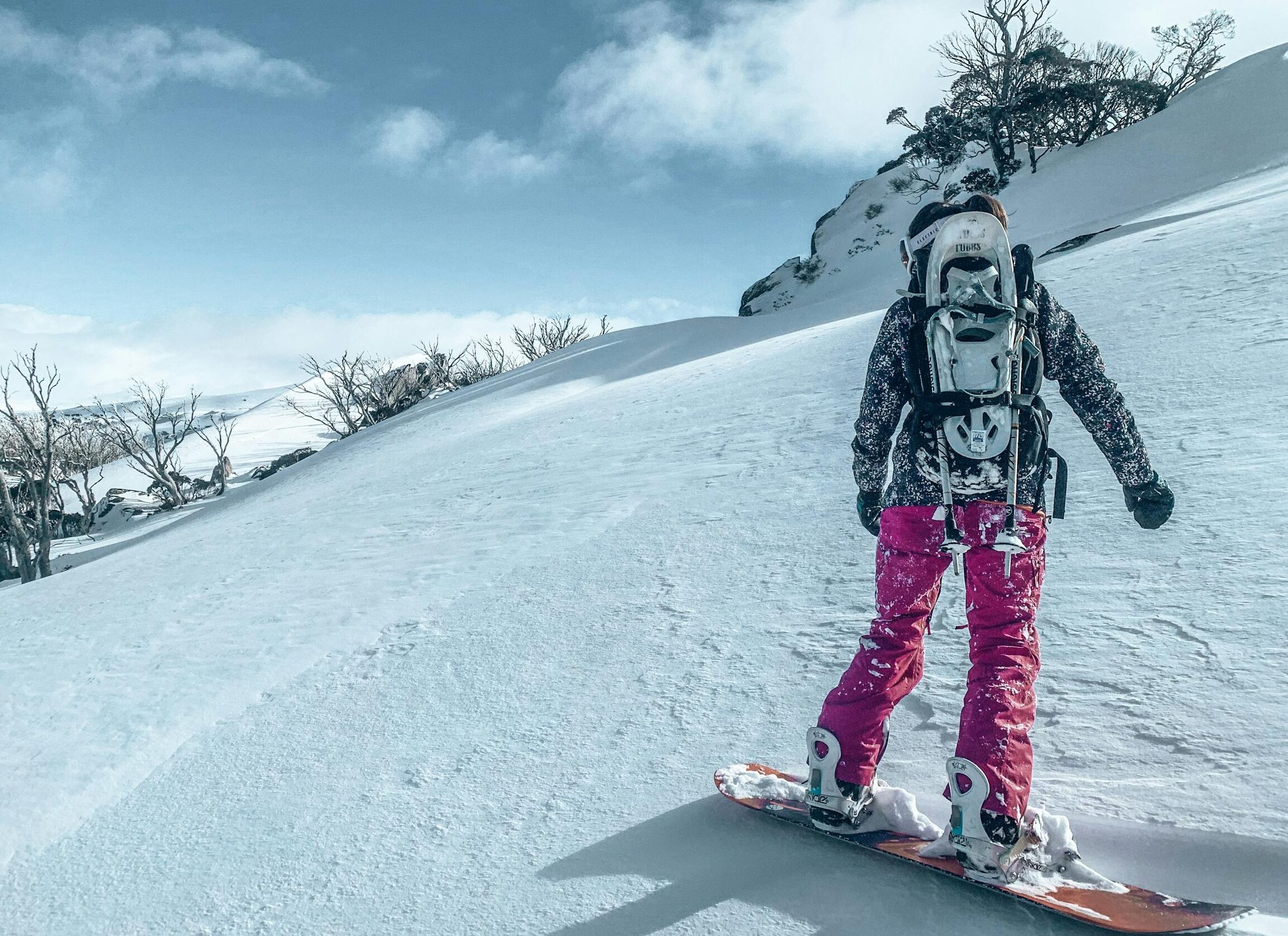Snowboarder descending snowy slope in Kosciuszko National Park, Australia.