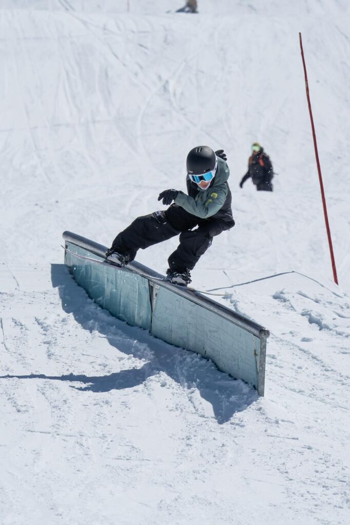 Snowboardeur en slide freestyle sur un rail glacé aux 2 Alpes