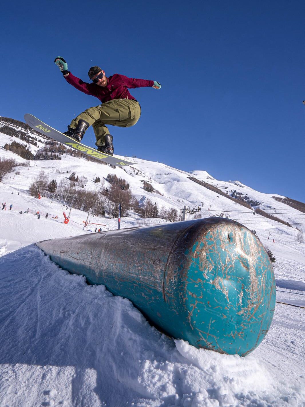 Snowboarder en slide sur un tube lors d’un shooting photo freestyle aux 2 Alpes