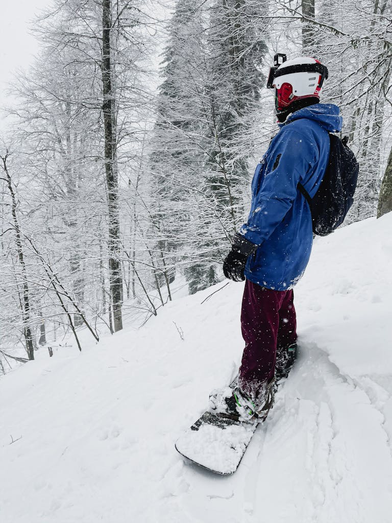 Snowboarder en sortie freeride dans une forêt enneigée aux 2 Alpes