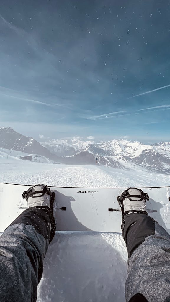 Vue depuis une planche de snowboard en sortie freeride avec panorama sur les 2 Alpes